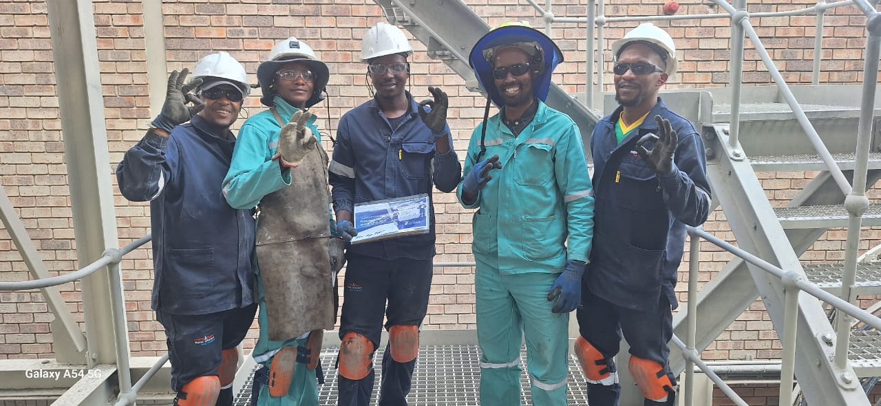 Mpozitho site team in PPE on an industrial walkway